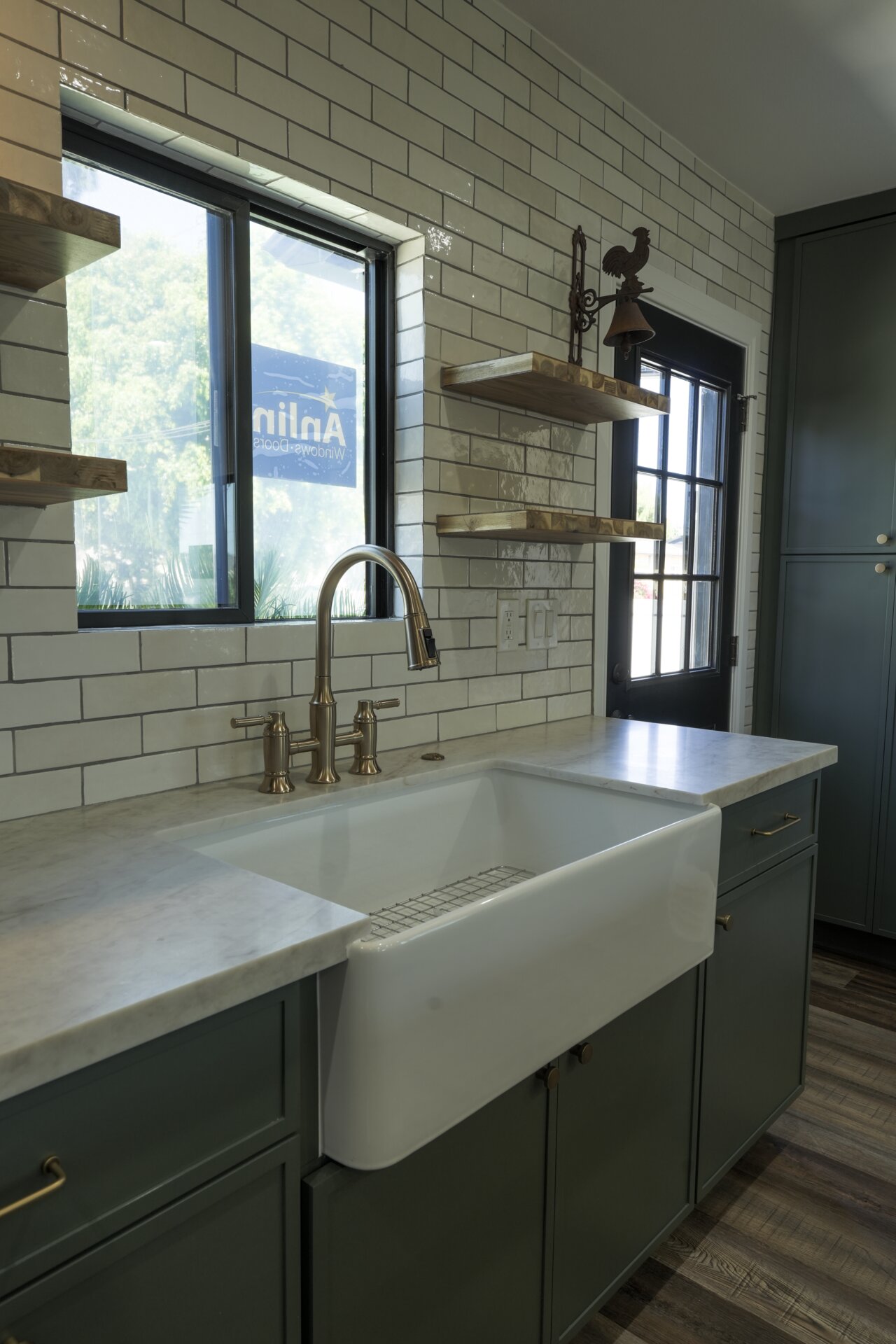 Kitchen sink with a white tile backsplash and warm wood counter