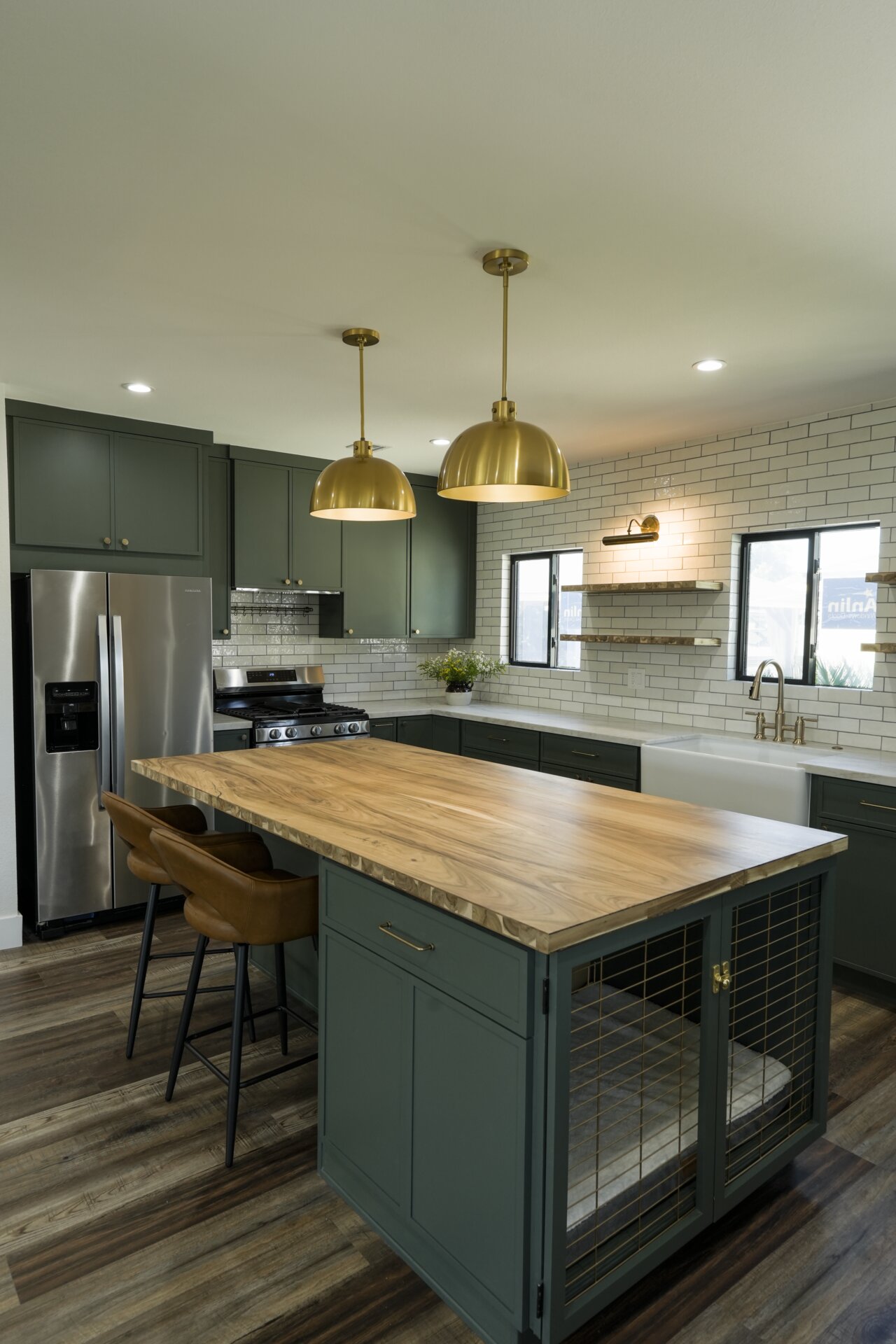 Green island cabinetry and wood countertop in an open kitchen