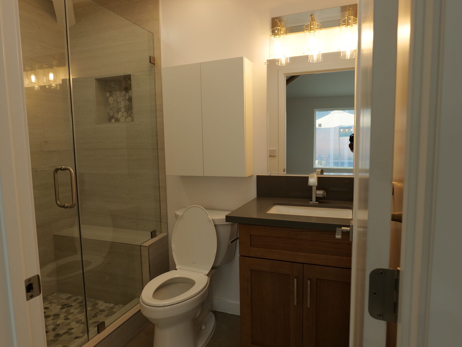 Wood bathroom vanity beside a tiled shower