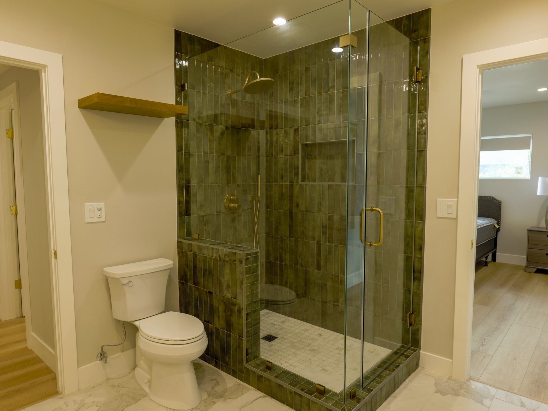 Spacious glass shower with stone tile and built-in seating