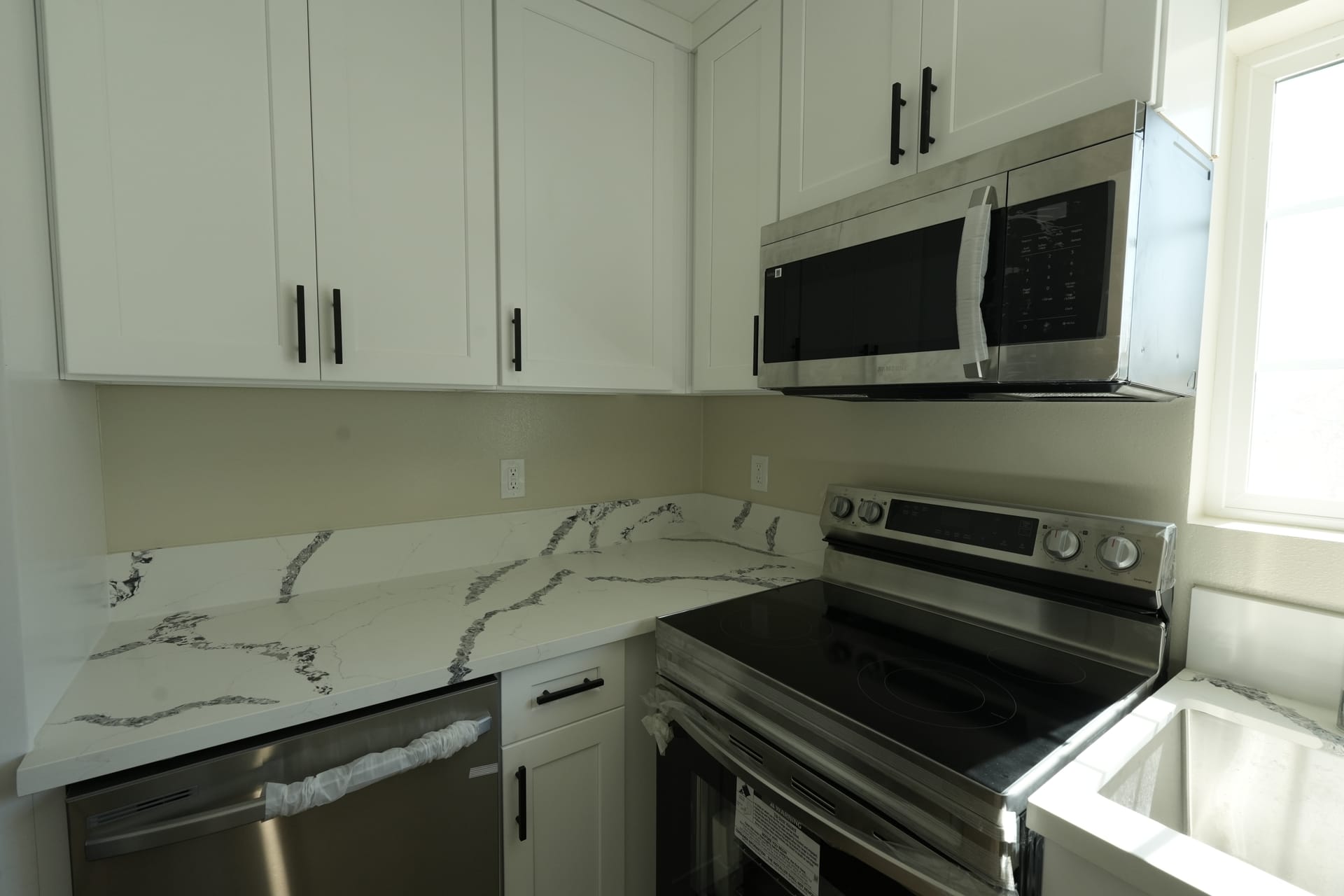 White kitchen cabinets and stone-pattern backsplash around the range