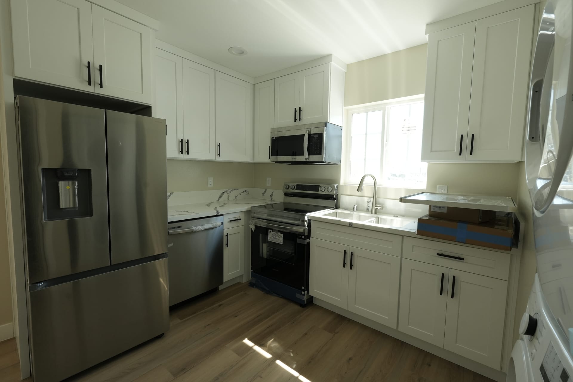 White kitchen peninsula beside a stainless steel refrigerator